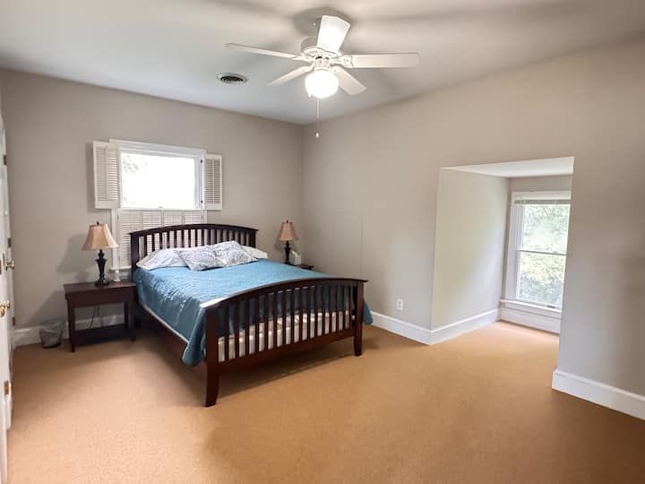 Spavaća soba na gornjem katu s bračnim krevetom i komodom; još jedan puni krevet nalazi se odmah izvan ove sobe