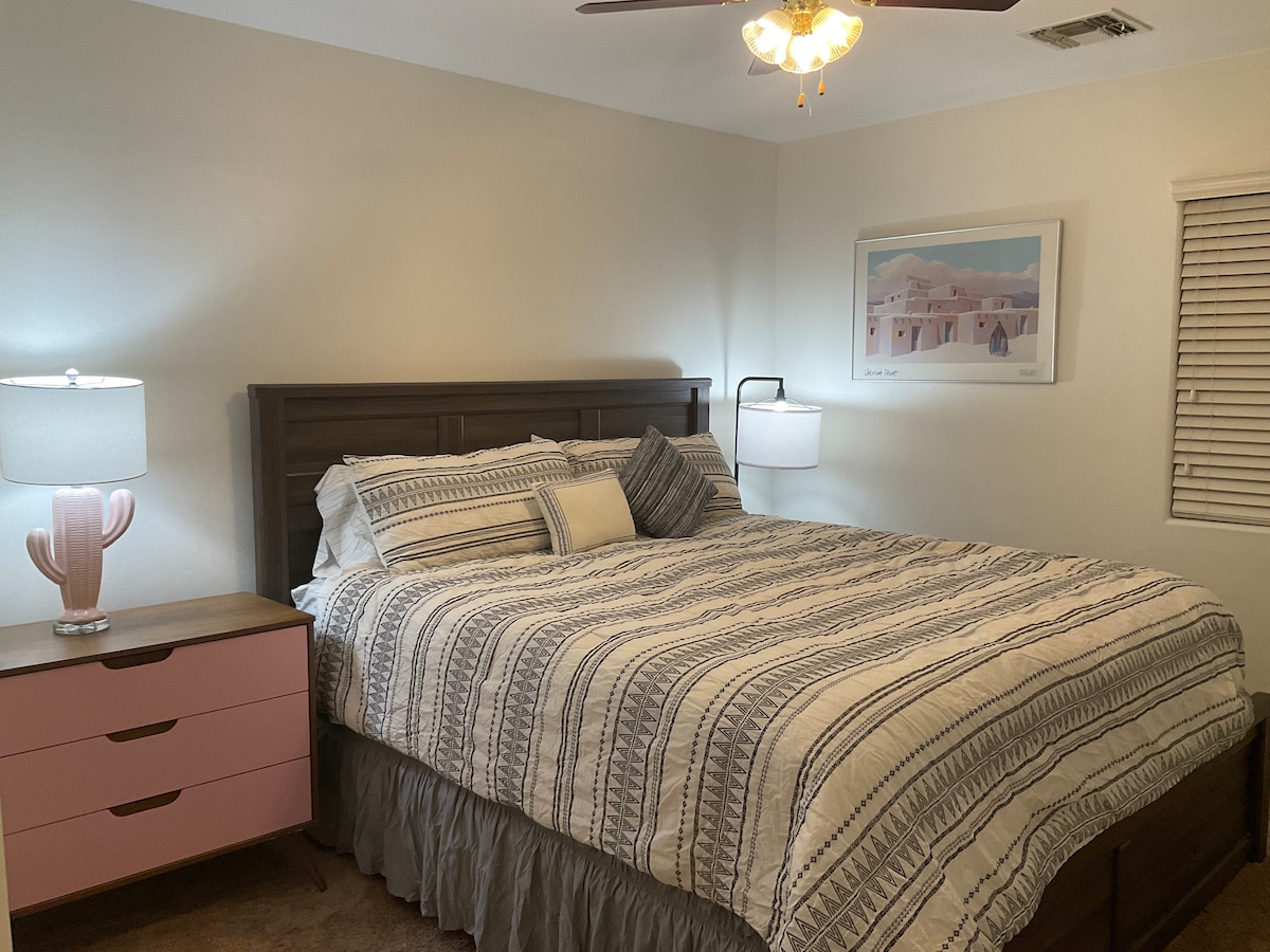 Pumzika katika chumba cha kulala chenye starehe kilicho na kitanda cha kifahari cha California, kinachotoa nafasi ya kutosha na starehe kwa ajili ya kulala usiku kwa utulivu.