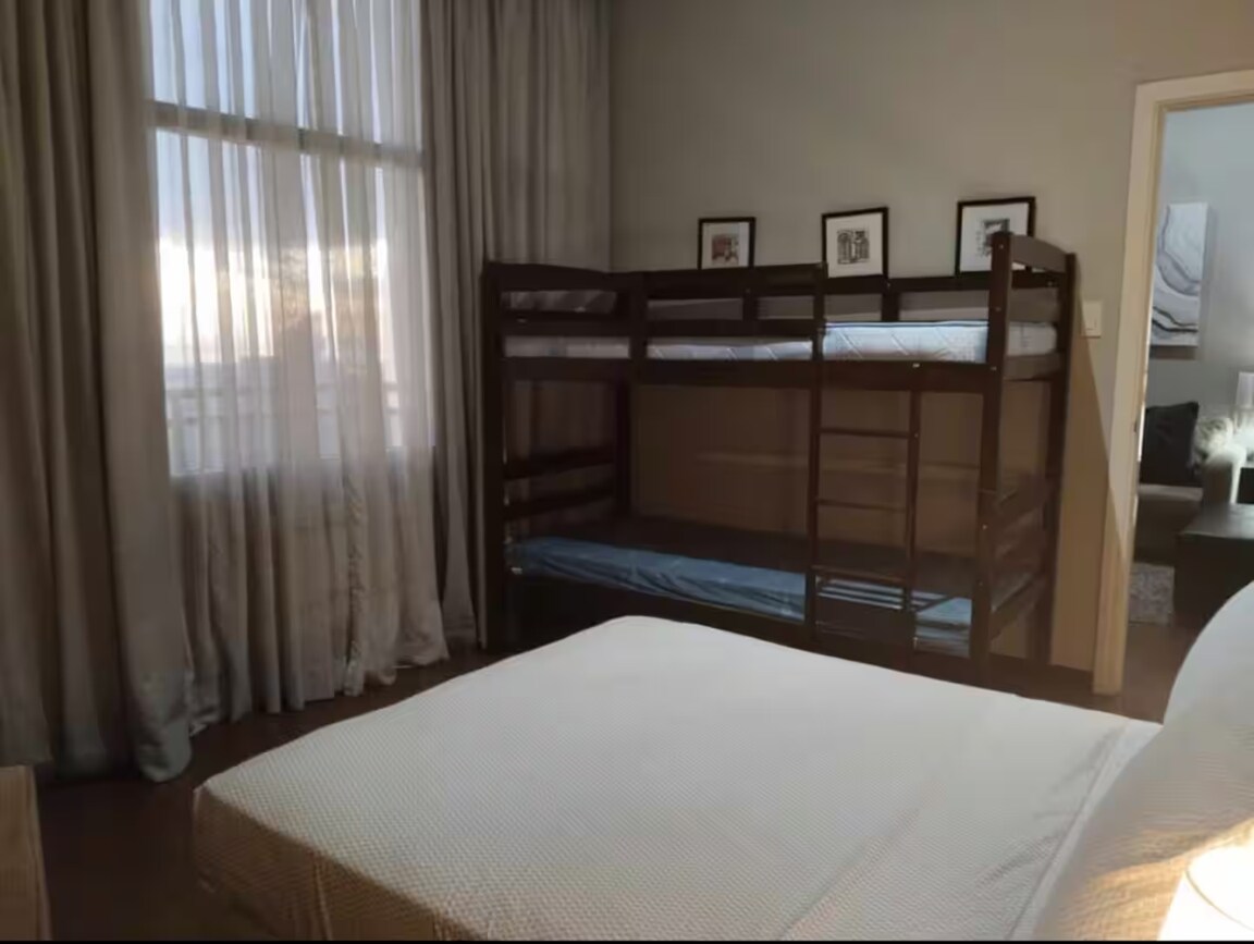 غرفة نوم ثانية بسرير مزدوج كامل وسرير بطابقين يمكن أن ينام عليه 4-5 أشخاص بشكل مريح. تحتوي على شرفة واسعة تطل على مدينة ماكاتي وخليج مانيلا وغروب الشمس المذهل. مرتبة إضافية متاحة عند الطلب مقابل تكلفة إضافية.