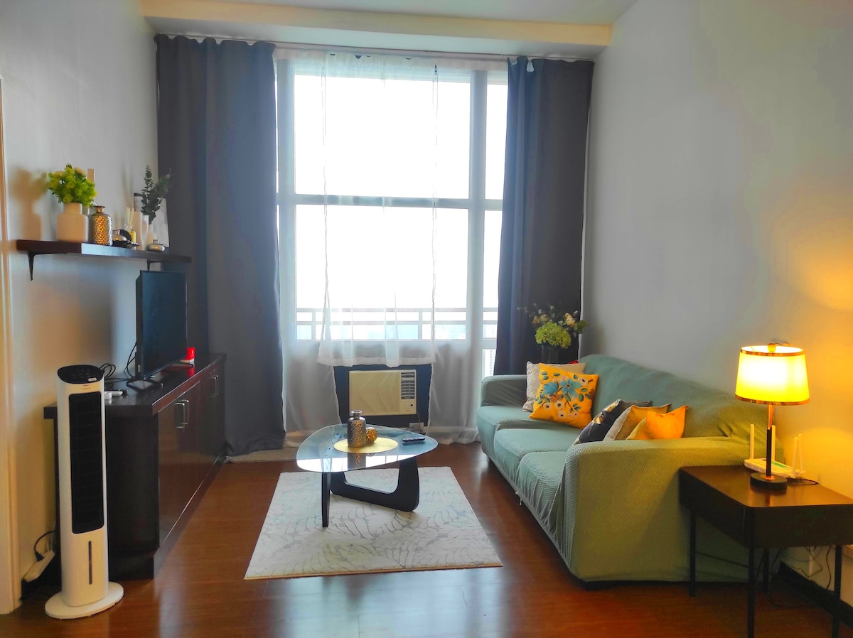 غرفة معيشة أنيقة مع أريكة مريحة بثلاثة مقاعد ومقعدين، وتلفزيون ذكي مع Netflix ويوتيوب، وواي فاي بسرعة 200 ميجابت في الثانية. استمتع بلحظات الاسترخاء أو أمسيات مشاهدة الأفلام أثناء الاستمتاع بإطلالات خلابة على مدينة ماكاتي من شرفتك الخاصة.