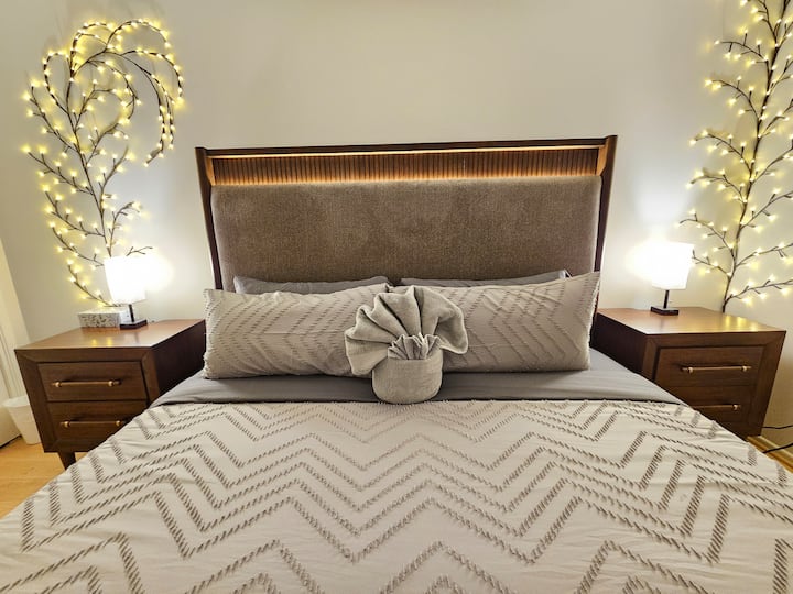 - King bed with modern lighting and elegant bedding  
- Cozy nightstands and stylish ambient glow design  
- Perfect rest space with calm relaxing atmosphere  