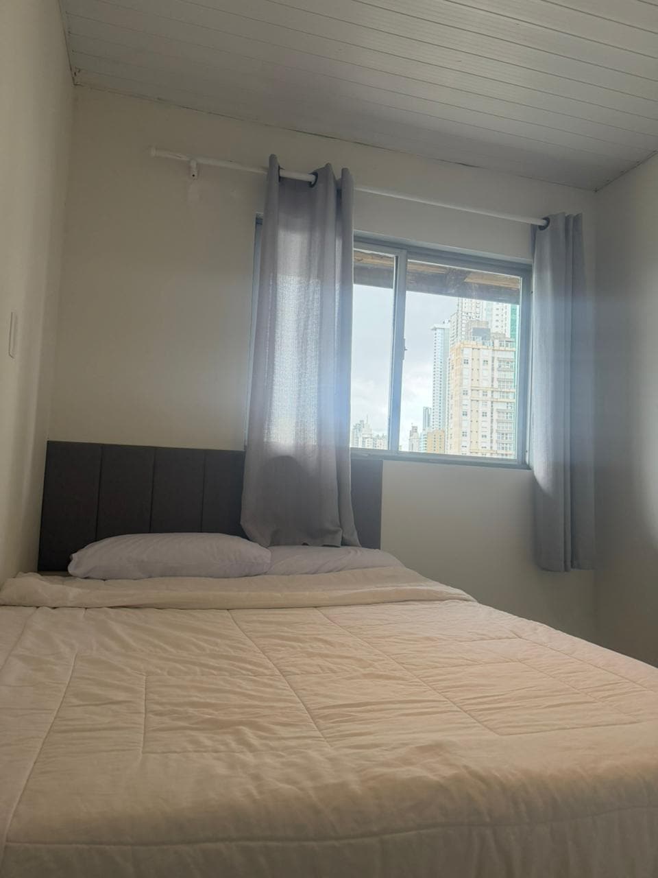 krevat dopio me çarçafë dhe ventilator.