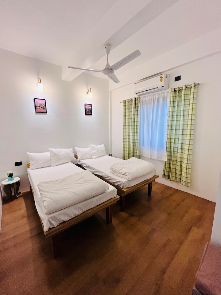 Ina vitanda viwili vya starehe vya mtu mmoja, benchi la mizigo/ kuketi, Bafu la kujitegemea, lenye fanicha ndogo kwa ajili ya mandhari safi na isiyo na mparaganyo. 
