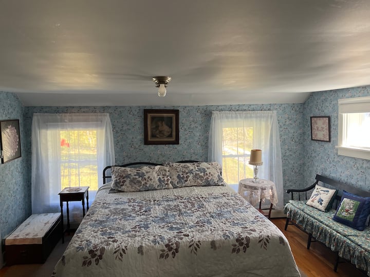 Posteľ veľkosti California King s komodami a zásuvkami.