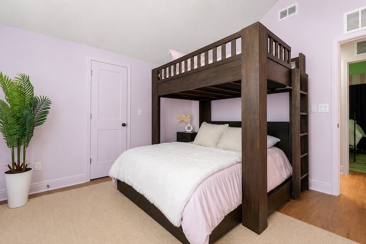 This spacious bedroom features a custom full-over-queen bunk bed, soft blush bedding, vaulted ceilings, and a calming lavender palette. Designed for comfort and group stays, it's the perfect place to recharge after exploring St. Augustine.