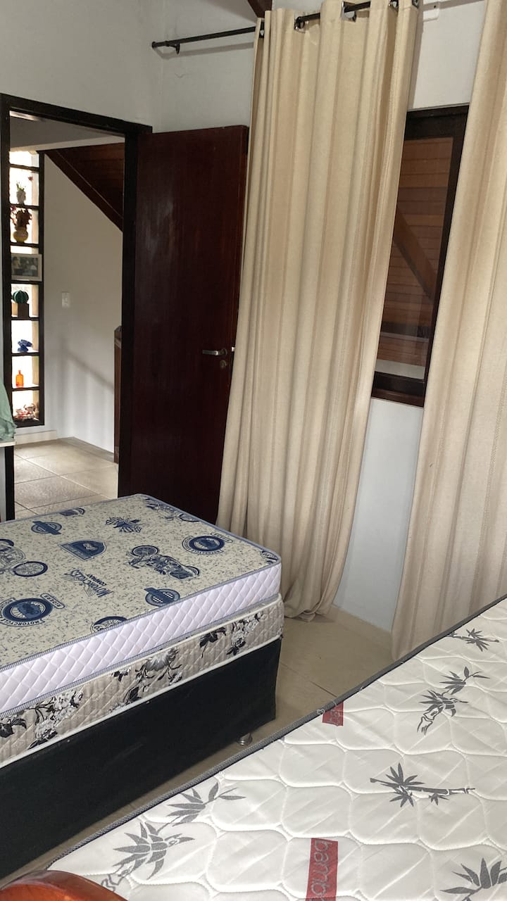 Habitación con dos camas individuales y dos colchones individuales. La sala de estar tiene un sofá cama doble. 