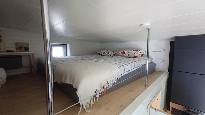 კიბე საძილე ლოფტამდე 180 სმ სიგანის ორადგილიანი საწოლით, გააღეთ ფანჯარა და თაროების კედელი შესანახად. Entresolplan.