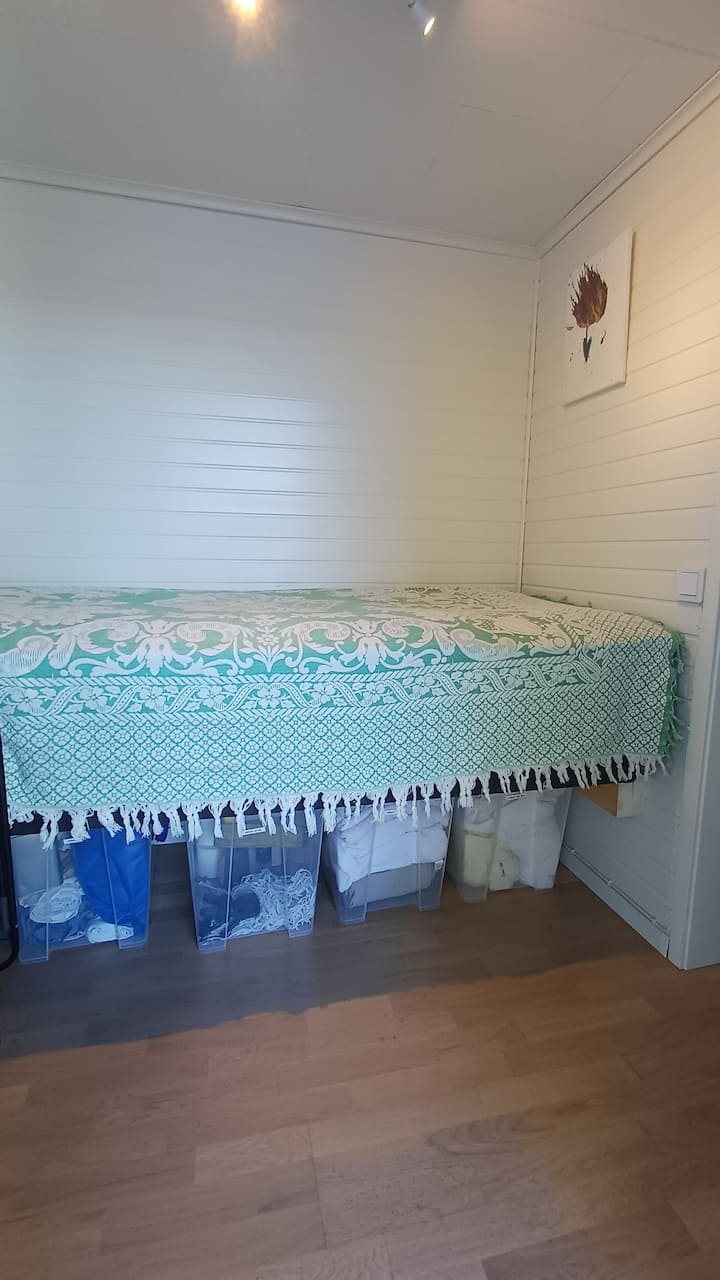 90 სმ სიგანის საწოლი. Ამ პატარა ოთახში არის ერთი შესასვლელი, ასევე, ტანსაცმლის საკიდი და გარკვეული სათავსო. Ის მიუყვება ამ პატარა სახლის სამზარეულოს სივრცეს.