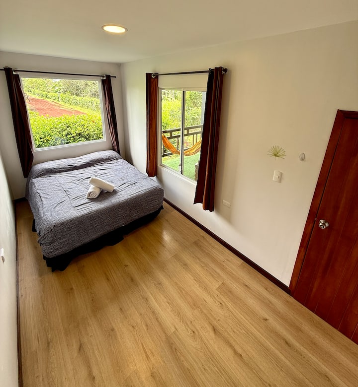 Chambre confortable et spacieuse avec lit queen, linge de maison frais et lumière naturelle.