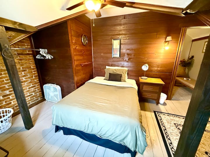 Full size bed with electric fireplace, closet and sitting areas.