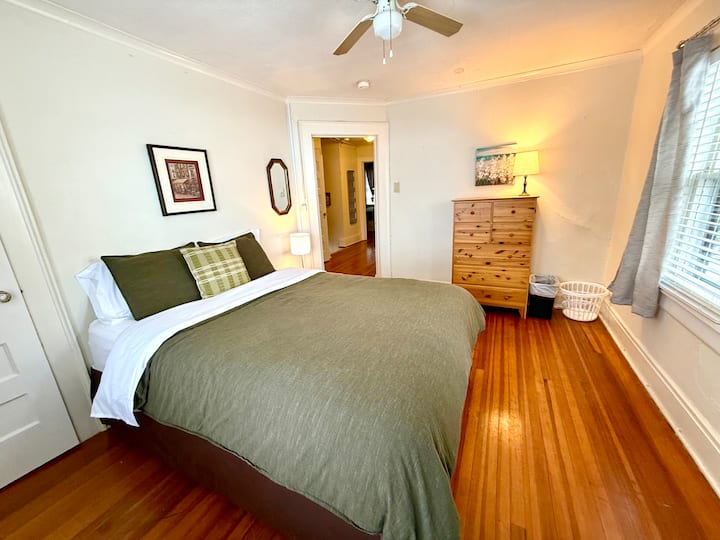 Queen size bed with closet and dresser.