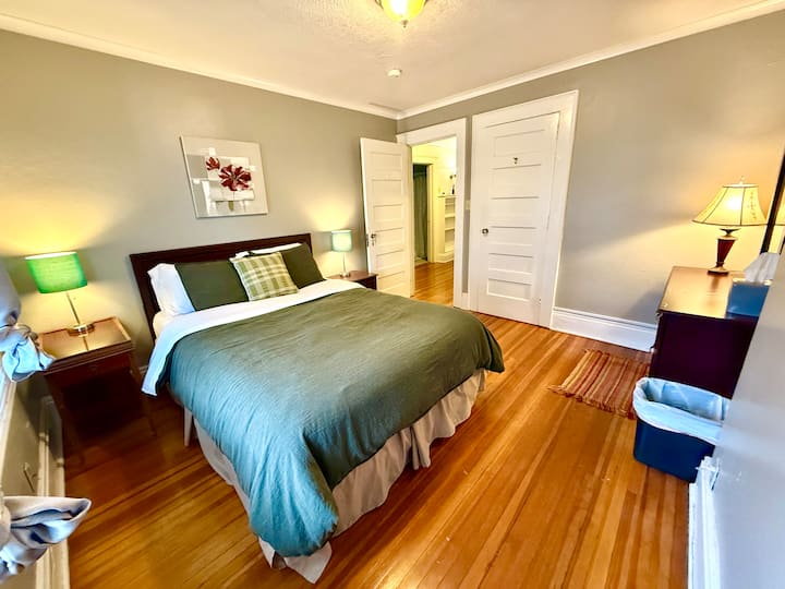 Queen size bed with closet and dresser.