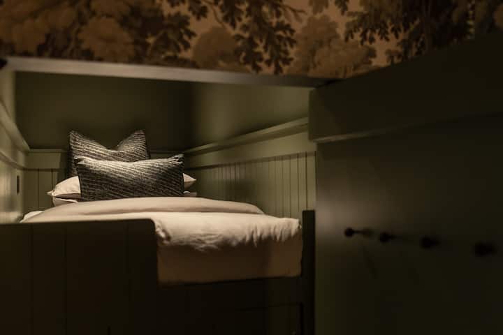 Единечен кревет на спрат зад скриена врата