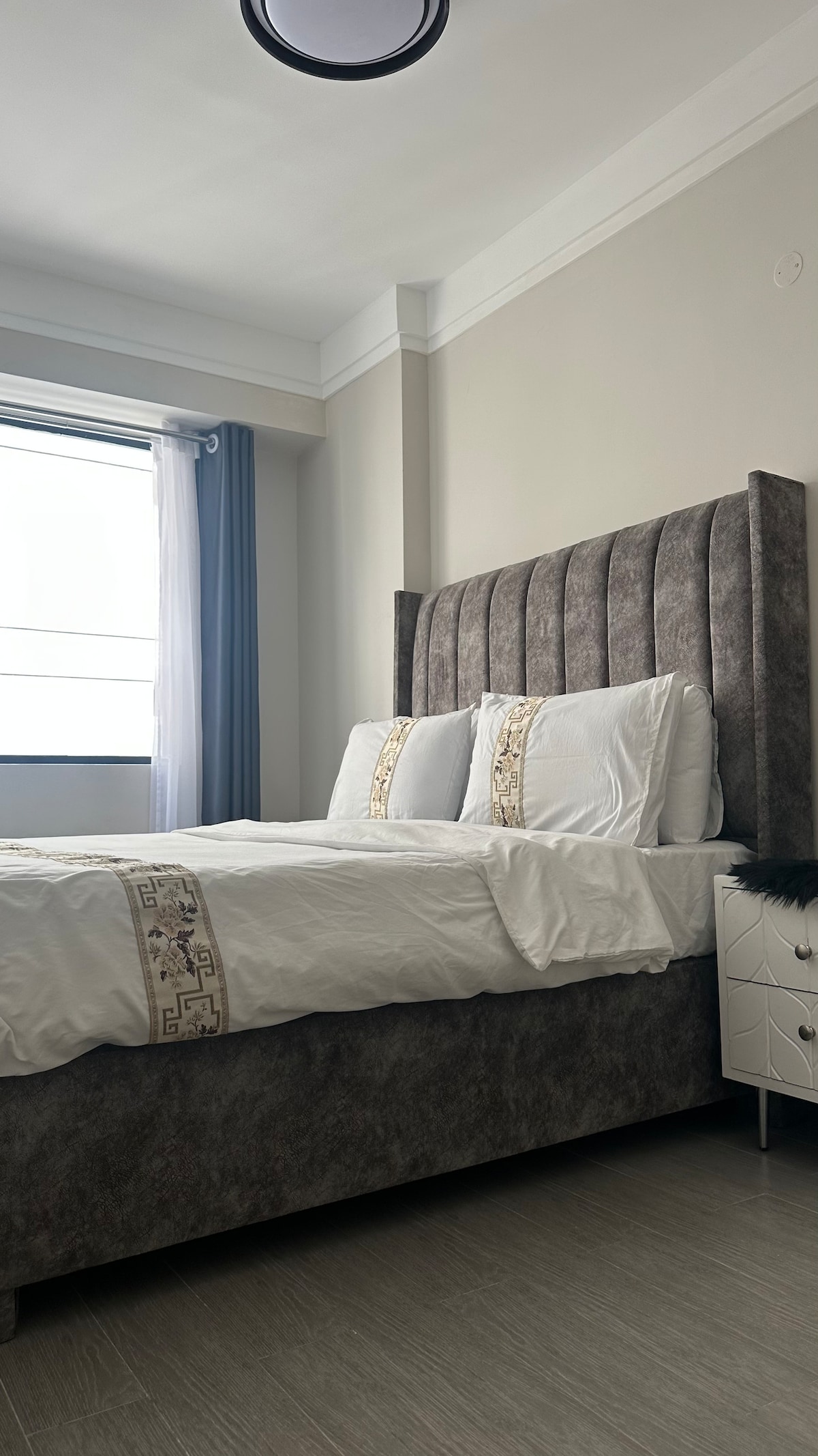 היכנסו לחדר השינה השקט שלכם הכולל מיטת קינג סייז מפוארת עם ראש מיטה דרמטי מקטיפה, שמבטיח נוחות אולטימטיבית ותחושה יוקרתית.