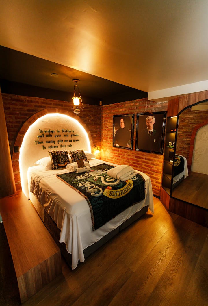 In the green room, mystery and elegance take over. The queen-size bed guarantees total comfort, surrounded by intense tones, enveloping lighting, and details that create a unique and enchanting atmosphere in the wizarding world. ✨