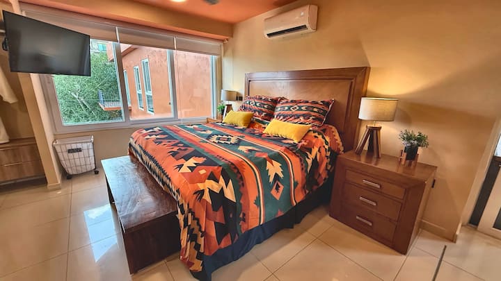 Rest comfortably in a spacious king bedroom filled with warm Mexican color, natural light and leafy views. Enjoy your own TV, air conditioning and a calm private retreat designed for restful nights and easy mornings.