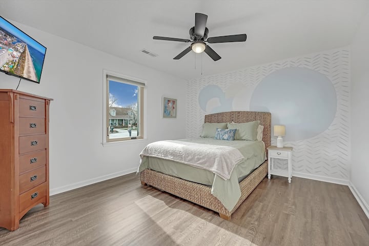 เตียงควีนไซส์และทีวีขนาด 42 นิ้วติดตั้งอยู่บนผนังในห้องพักที่อบอุ่นนี้นอกจากนี้ยังมีมู่ลี่สีเข้มในห้อง