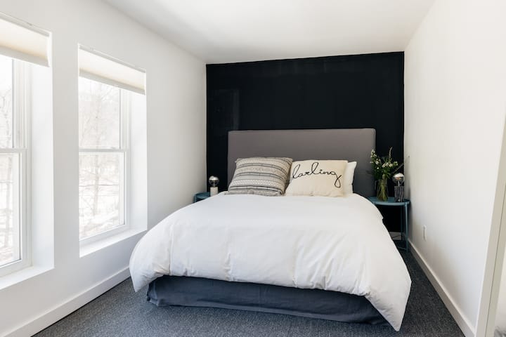 Serenity in the treetops. This bedroom overlooks the back meadow and the edge of the forest