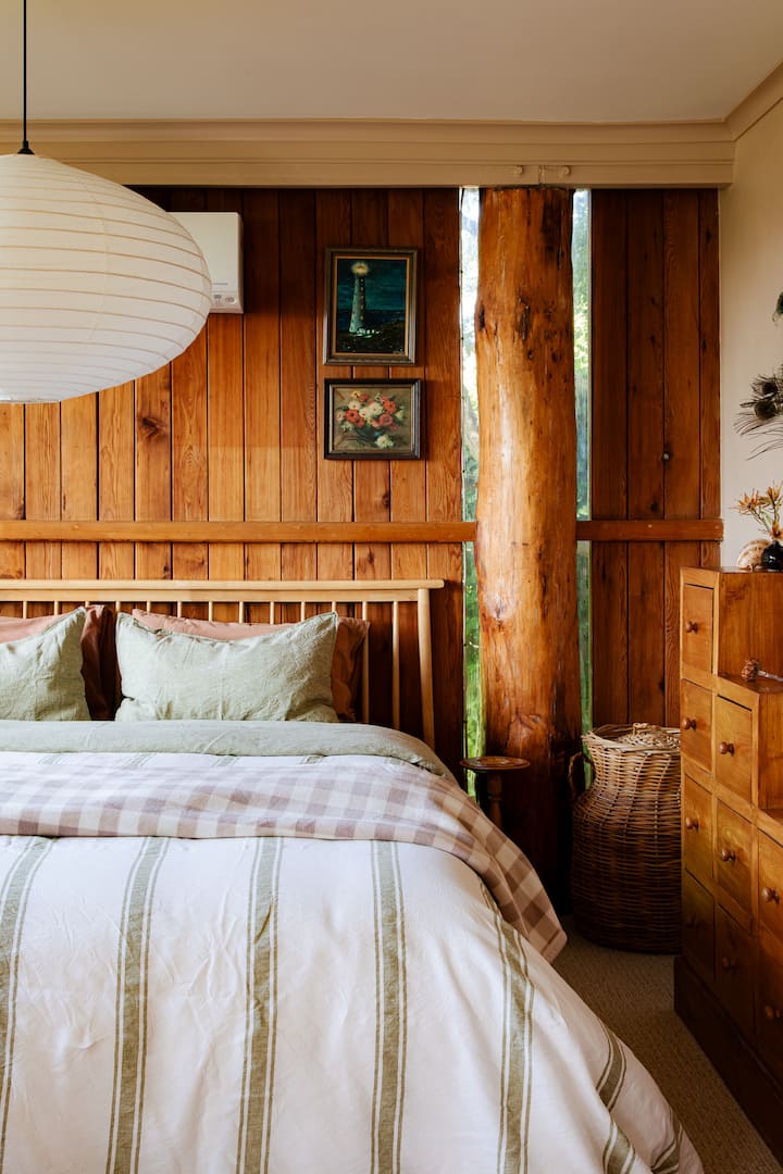Drift into a peaceful slumber in the luxurious king-sized bed, adorned with soft linen. Framed by warm wooden walls, this relaxing space invites you to recharge, cocooned by nature.