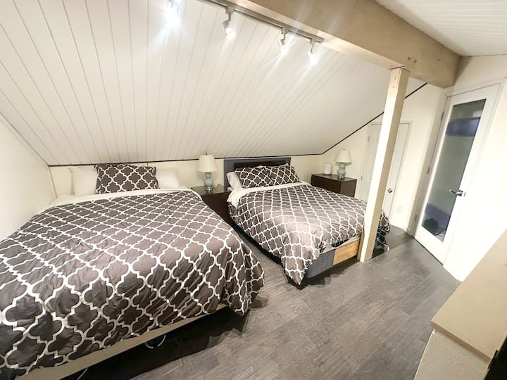 חדר שינה בלופט עם 2 מיטות קווין סייז וחדר רחצה - נגיש באמצעות גרם מדרגות ספירלי