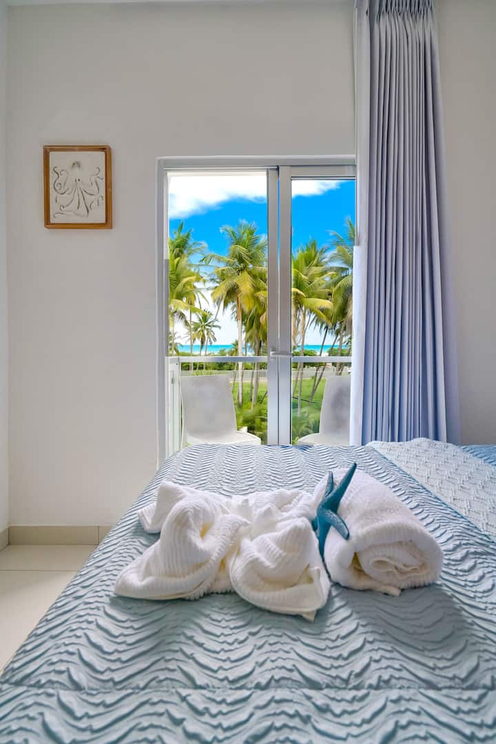 Dhomë gjumi me fllad oqeani

Një dhomë gjumi e qetë dhe ftuese me çarçafë të butë dhe një ballkon me pamje nga palmat dhe deti përtej, e përkryer për mëngjese të qeta dhe net të qeta.
