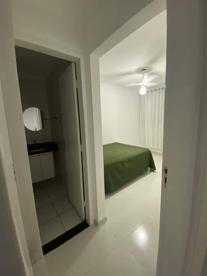 Suite con cama doble, ventilador de techo, cortina y ventana con red de seguridad.