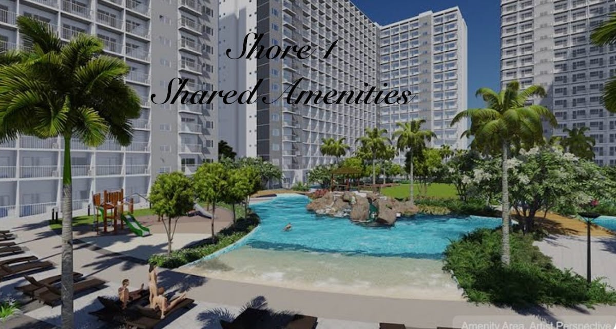A tropical landscape showcases a shared pool surrounded by lush greenery. Comfortable lounge chairs are arranged near the water, while a playground and a rocky feature are visible in the background. The modern buildings create a backdrop for this inviting amenity area.