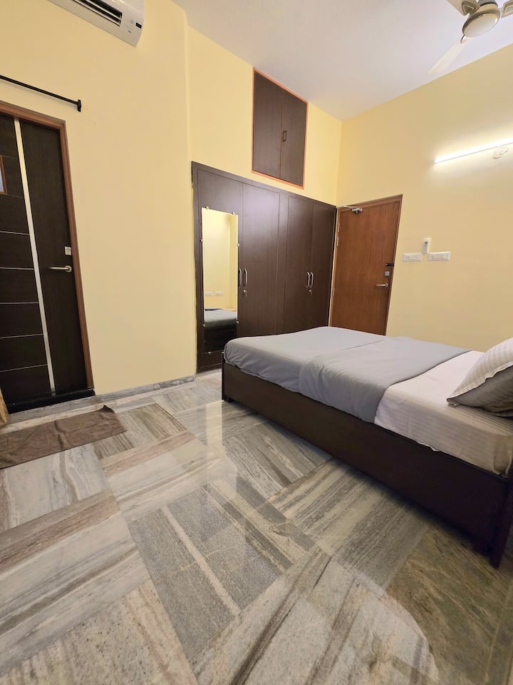 Acogedor segundo dormitorio con baño adjunto, aire acondicionado, mesa de trabajo y un amplio armario.