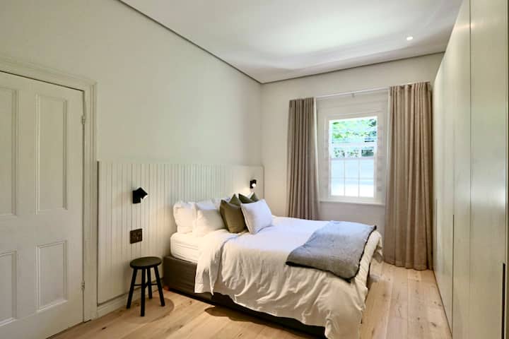 เตียงควีนไซส์ที่สะดวกสบายพร้อมผ้าปูที่นอนสีขาวระดับพรีเมียมและไฟด้านข้างแบบปรับได้ ชาร์จอุปกรณ์ทั้งหมดข้ามคืนได้อย่างสะดวกด้วยพอร์ต USB ประเภท A และ C ในตัว 