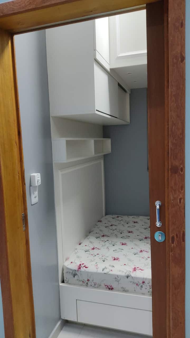 კომპაქტური საძინებელი, რომელშიც არის 135x191 სმ ზომის საწოლი და მის ზემოთ 89x191 სმ ზომის ერთადგილიანი საწოლი (ორიადგილიანი საწოლის სტილში), ასევე, კედლის ვენტილატორი.