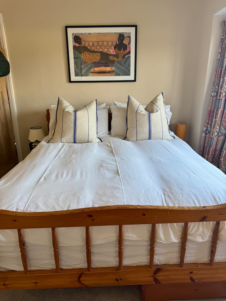 Уютна спалня с голямо двойно легло и много предмети от пътуванията ни.