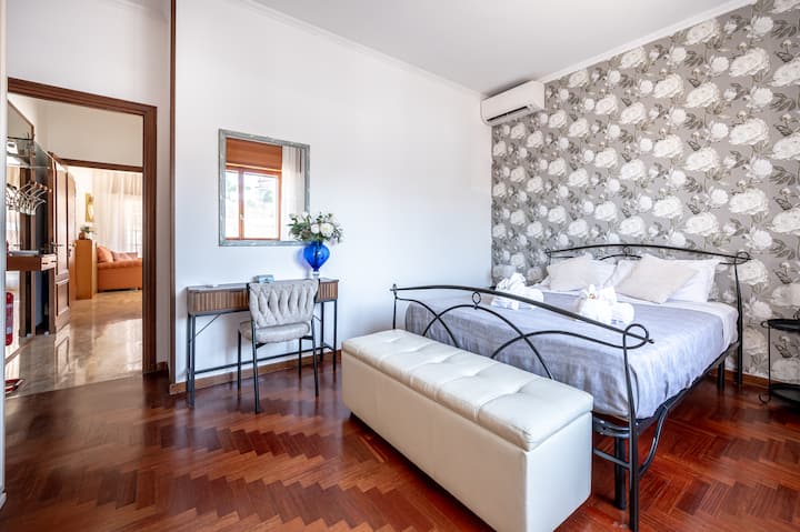 Camera con letto matrimoniale, armadio, Smart TV, beauty con specchio, aria condizionata, riscaldamento, appendiabiti, panca contenitore, culla per neonato (a richiesta), asse e ferro da stiro, tapparelle elettriche, tende oscuranti e zanzariere.