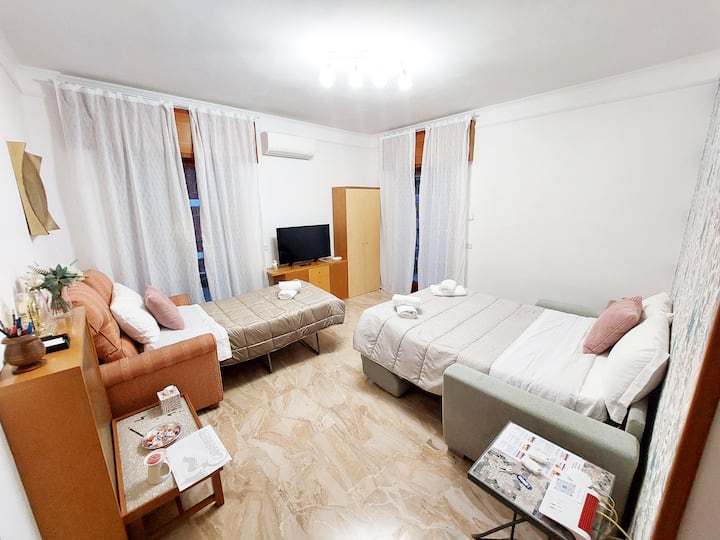 Ampio soggiorno con aria condizionata e riscaldamento a termosifoni, armadio, cassettiera, divano letto alla francese e singolo, tavolini a mosaico, comodino, Smart TV, tende oscuranti, tapparelle elettriche e zanzariere. Doppio accesso al terrazzo.