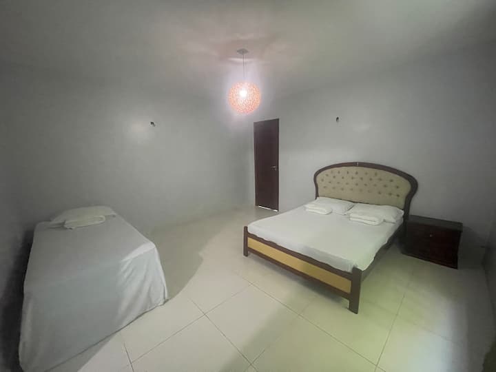 Areia suite on the 1st floor of the house, with 1 double bed, 1 single bed, split air conditioning, blackout curtain, hammock hooks, clothes rack, toilet with attached cistern, bidet, shower with Blindex enclosure, mirror, countertop sink, hangers.