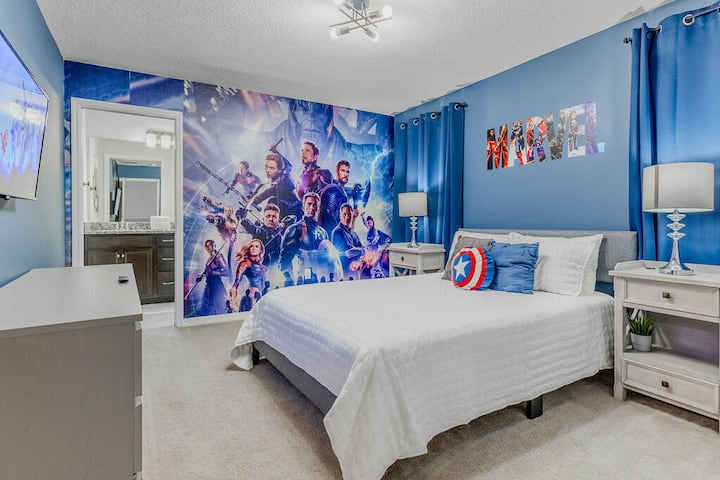 Step into this vibrant bedroom, featuring a captivating mural and soft blue walls that create a playful atmosphere. The comfortable bed is complemented by stylish side tables and bright window treatments, ensuring a restful stay.