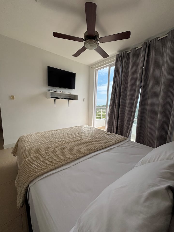 Chambre avec télévision, balcon et salle de bain privée dans la chambre