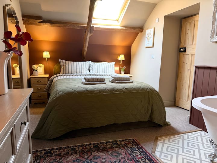 Master bedroom with King size ottoman bed and roll top bath