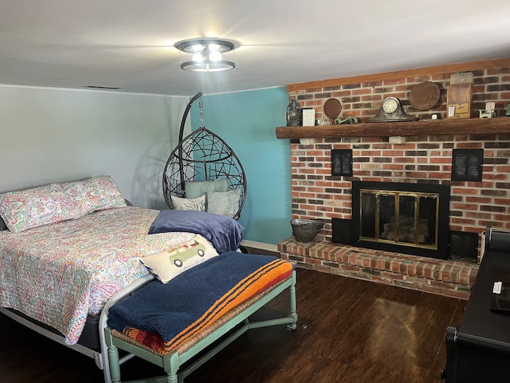 Кревет со целосна големина покрај каминот.