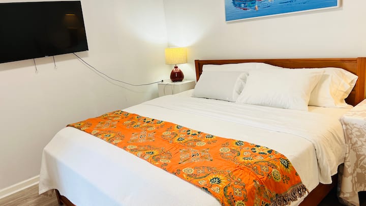 Dormitorio cómodo con cama tamaño king de California y TV inteligente.