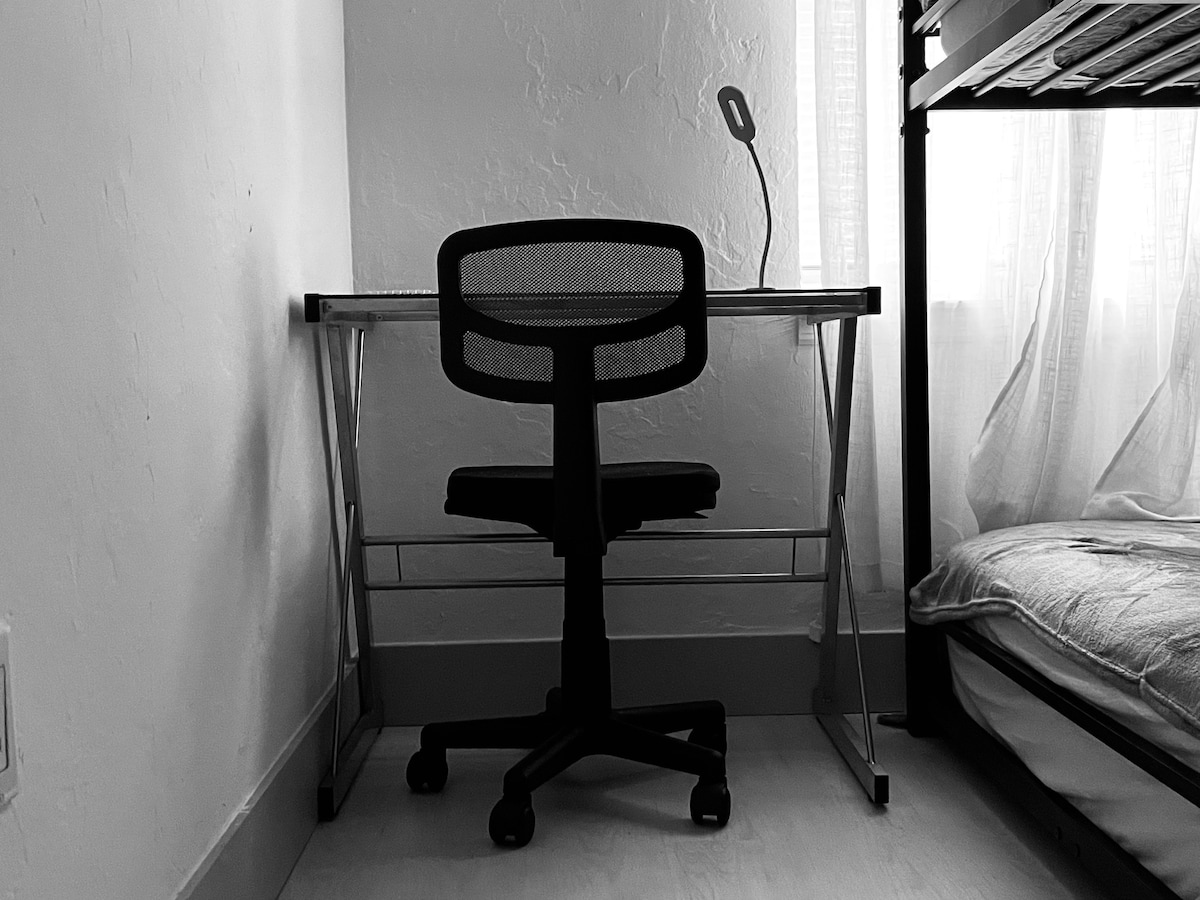 სამუშაო სივრცე მოძრავი სკამითა და ლამპით.