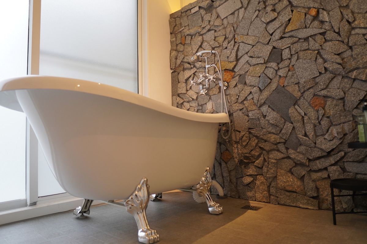 猫足バスタブと、大島石を貼ったおしゃれなバスルーム。