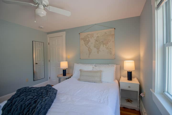 Comfortable queen bed with plush bedding, cozy linens, plenty of pillows, and a full-length mirror.