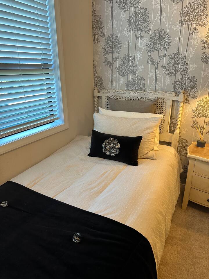 سرير مفرد كبير في غرفة النوم الثانية