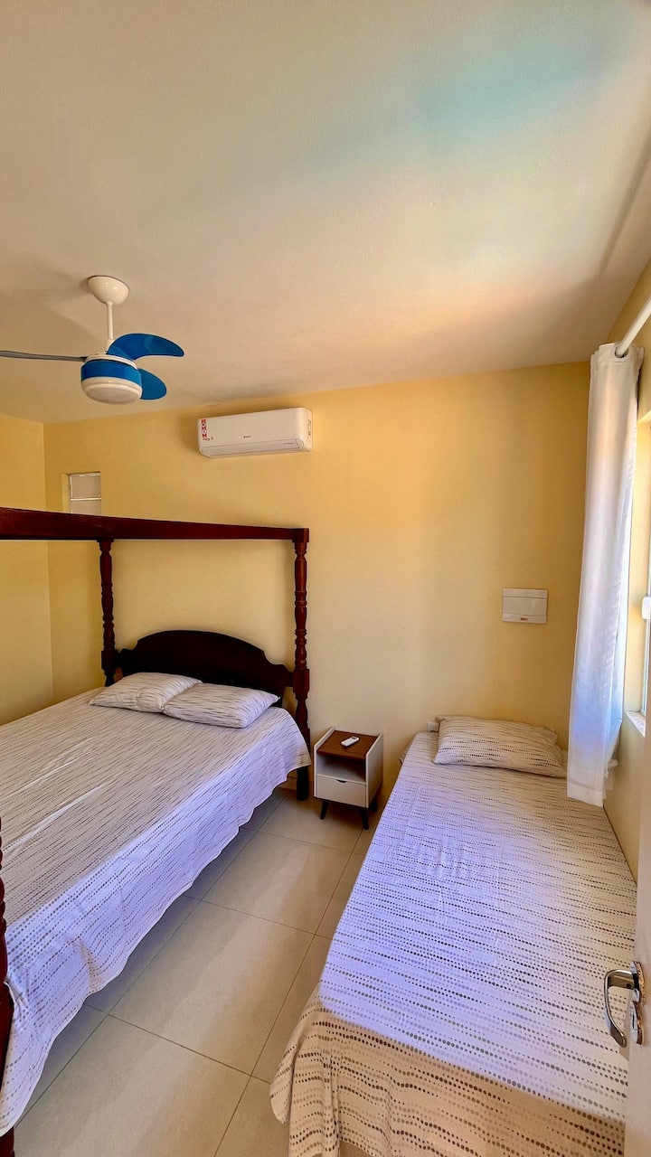fica na parte da frente com guarda roupa, uma cama casal e uma solteiro e um colchão extra, ventilador de teto e ar condicionado.