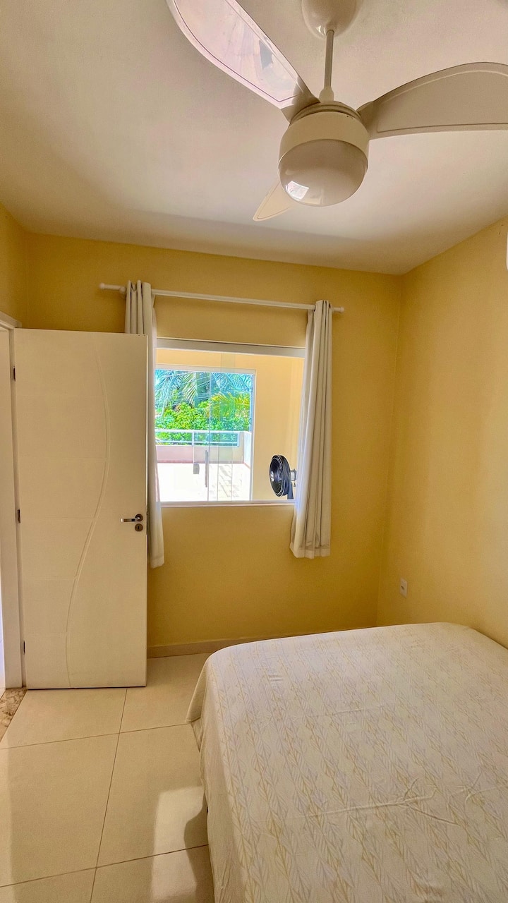 quarto do meio com uma cama de casal, cômoda, ventilador de teto e ar condicionado