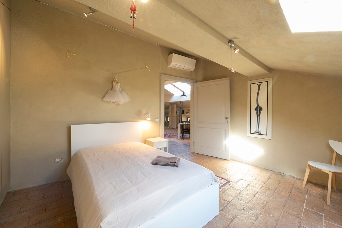 Una cama francesa, una pared con armarios equipados, un pequeño escritorio de época; hay una ventana baja y un Velux que se puede abrir y oscurecer. Aire acondicionado independiente con control remoto, luz de lectura, LED de pared