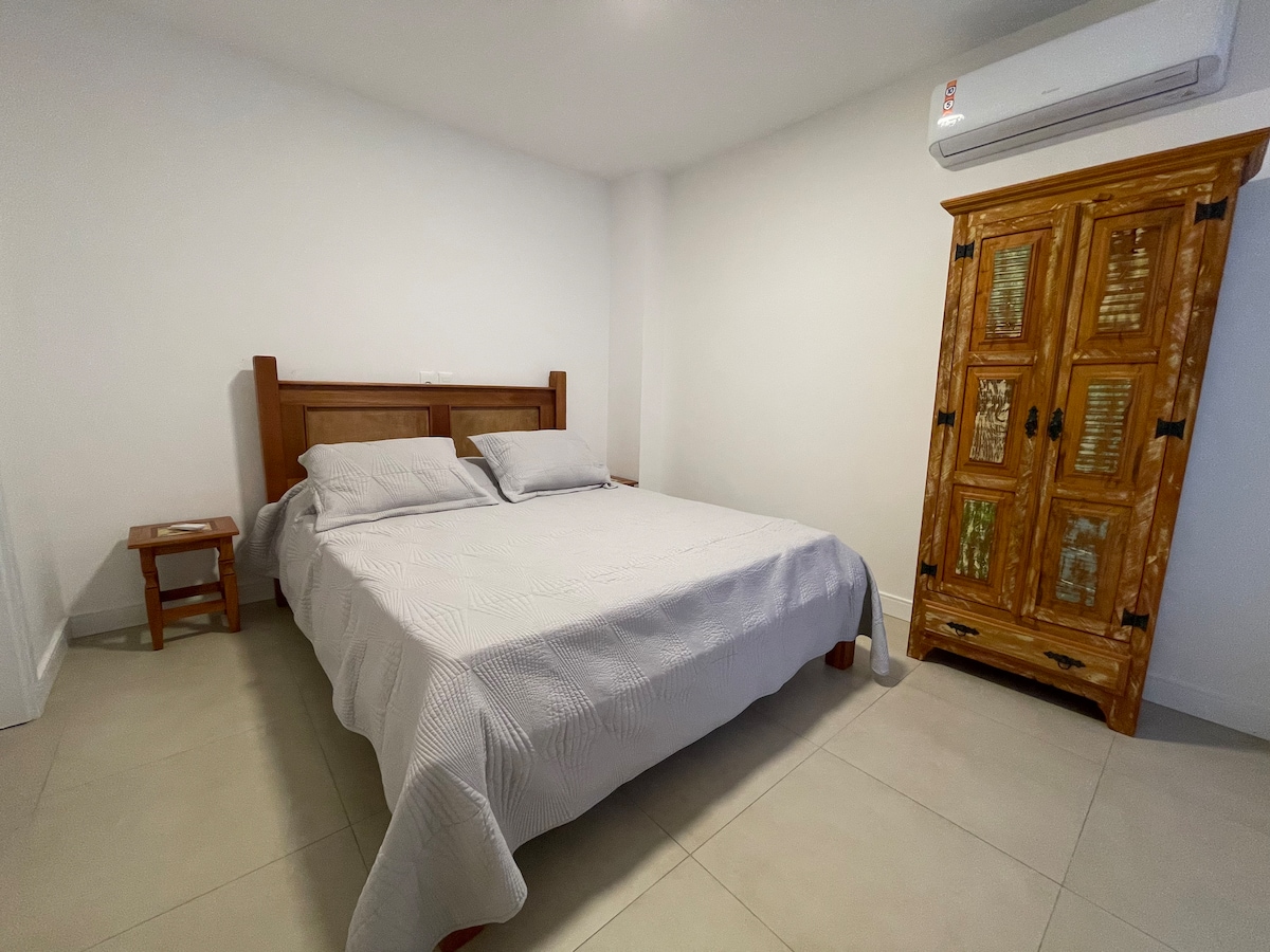 En suite con cama tamaño queen que se abre a una terraza individual con espacio de trabajo.