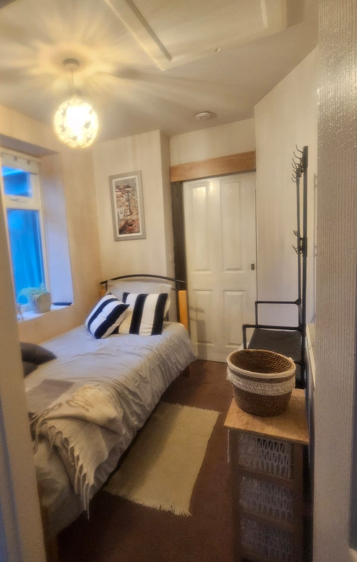 Dormitorio individual con puerta corrediza que ofrece privacidad adicional y vistas tranquilas al exterior.