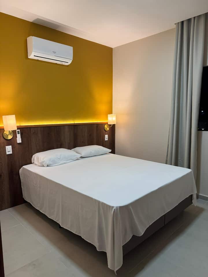 חדר שינה עם מיטת קווין סייז זוגית וחדר רחצה 