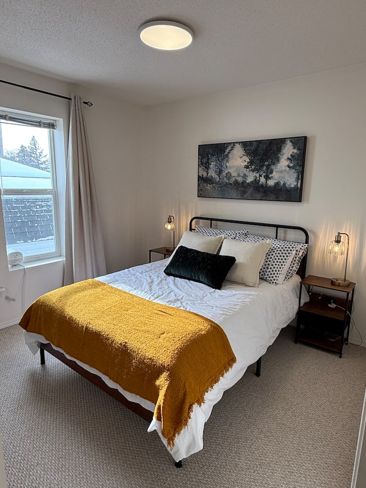 Bračni krevet s ormarom za prtljagu i vješalicama.